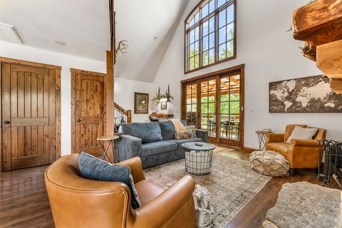 Comfortable living room seating arranged around the wood-burning stone fireplace