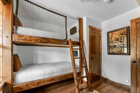 Bunk beds with a wooden ladder and crisp white bedding