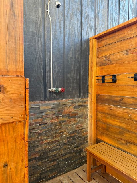The outdoor shower added in 2026, built in cedar with a rainfall shower head