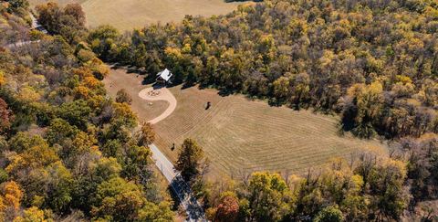 Aerial view of the 90-acre property with the cabin set among fields and forest